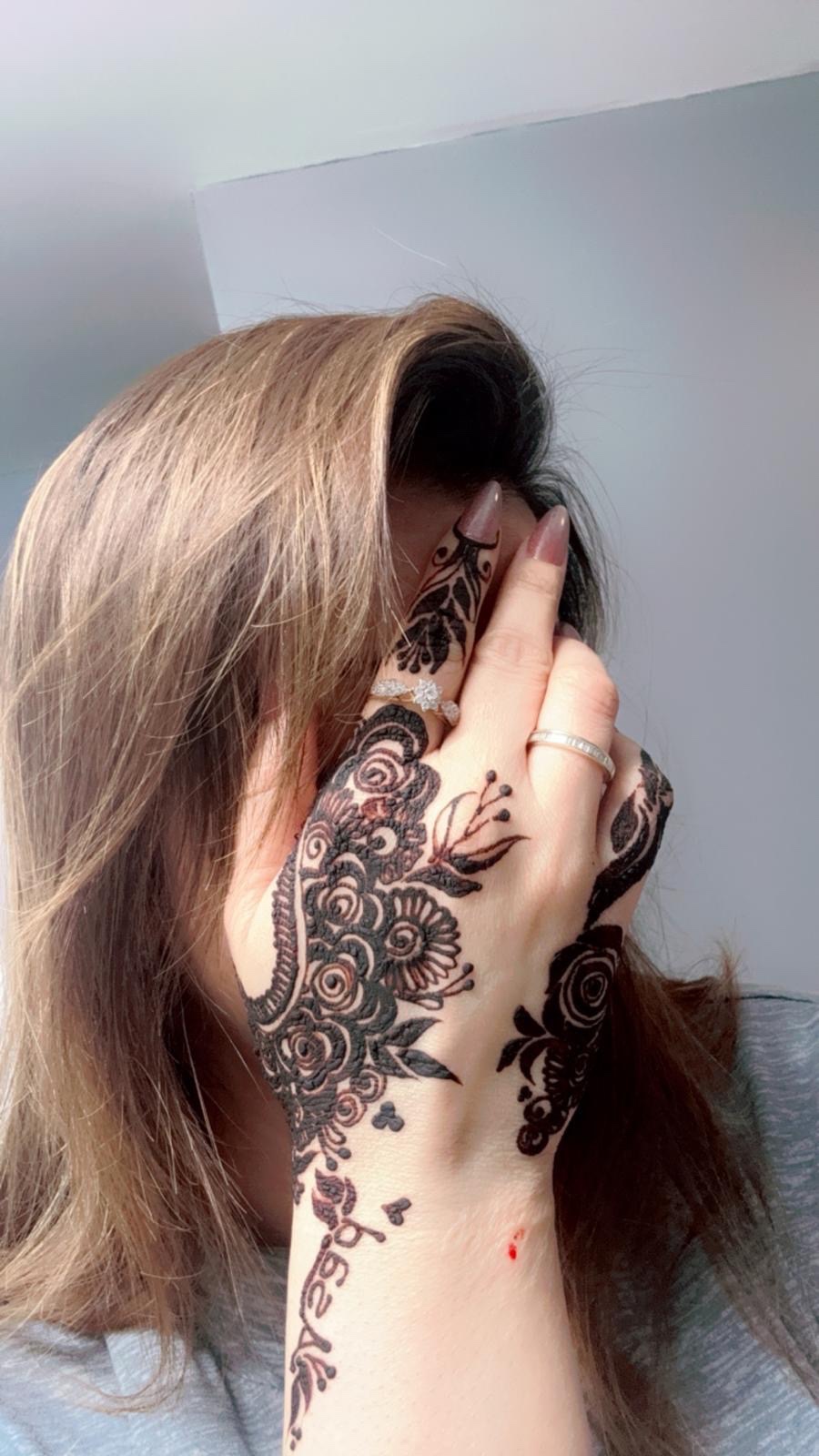 Dense dark rose henna across hand and wrist