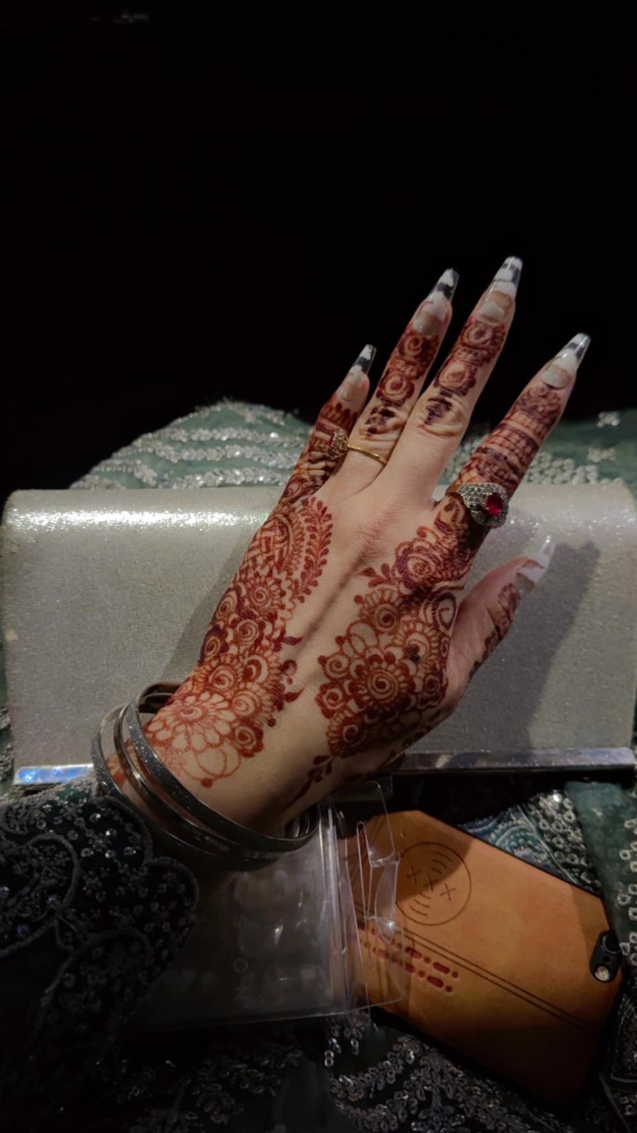 Detailed floral mehndi with long nails