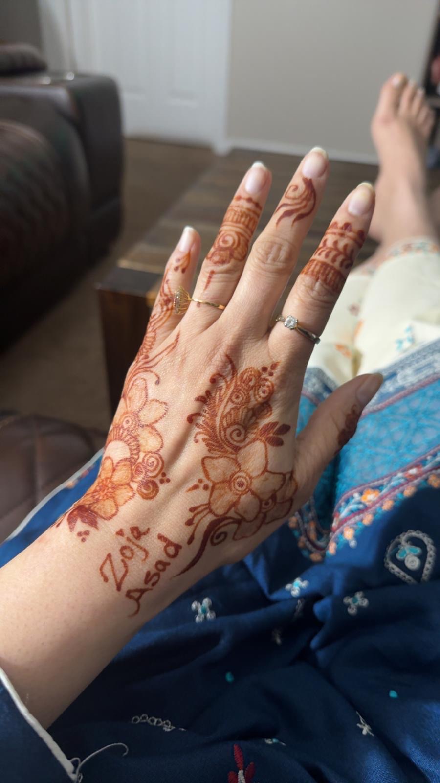 Floral henna with name on hand